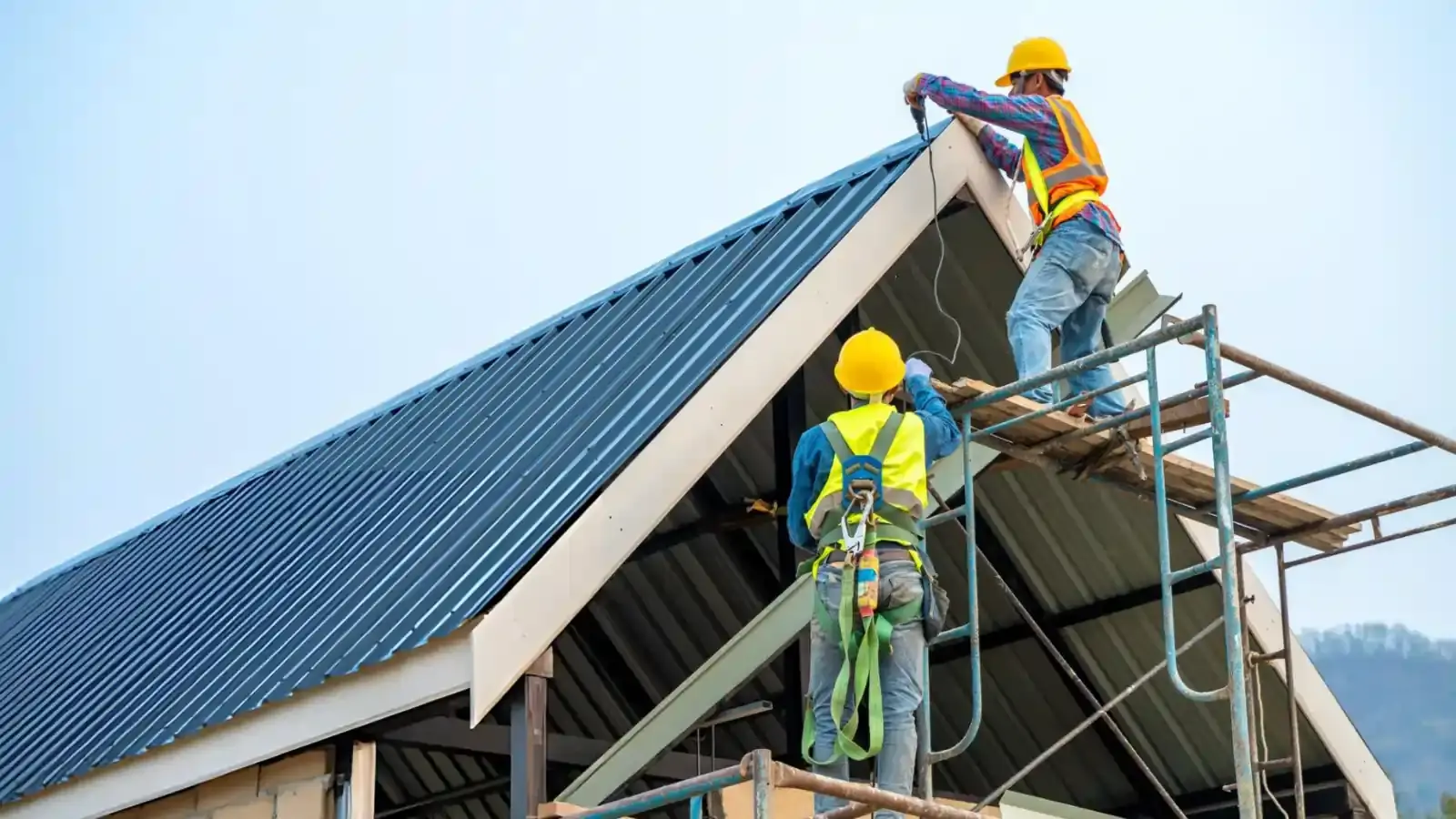 Two workers repairing and installing a roof, ensuring safety and durability