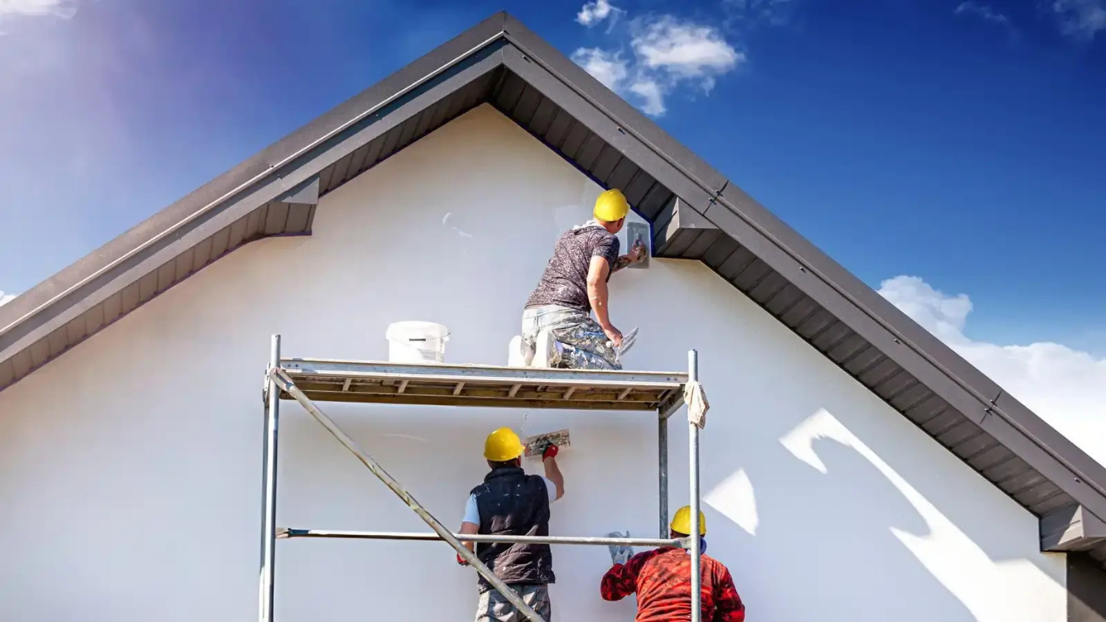 Three professional painters working together to remodel a home in Pennsylvania, applying fresh paint for a clean, updated look.